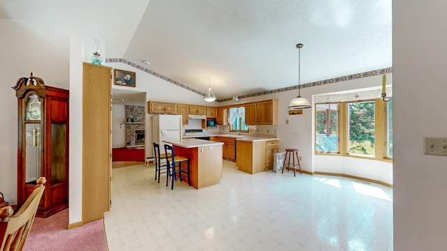 120 6th St SW, Chatfield, MN 55923 - kitchen featuring vaulted ceiling, freestanding refrigerator, under cabinet range hood, a breakfast bar, and range with electric stovetop