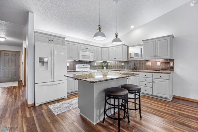 3437 26th Ave S, Fargo, ND 58103 - kitchen with white appliances, a textured ceiling, decorative backsplash, a kitchen island, and dark wood-type flooring