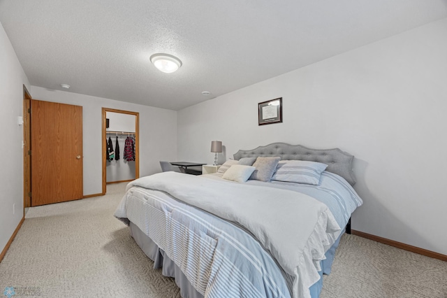 3437 26th Ave S, Fargo, ND 58103 - bedroom with light carpet, a textured ceiling, and a walk in closet