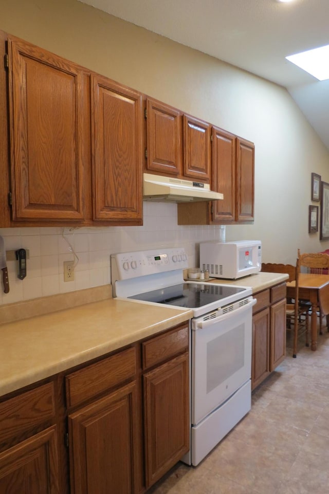 912 3rd St N Unit 7, Cold Spring, MN 56320 - kitchen featuring white appliances, under cabinet range hood, brown cabinetry, tasteful backsplash, and lofted ceiling