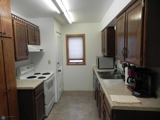 1610 9th St N, Fargo, ND 58102 - kitchen featuring white range with electric stovetop, under cabinet range hood, light countertops, and dark brown cabinets