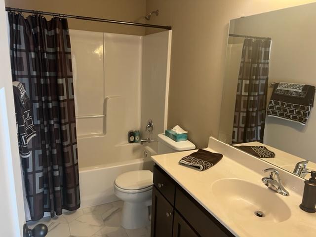 23648 Lily St NW, Saint Francis, MN 55070 - bathroom featuring vanity, shower / bath combo, and marble look tile flooring