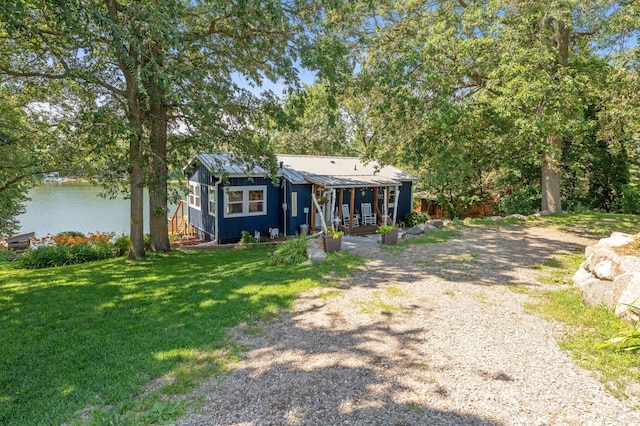 13491 80th St NW, Annandale, MN 55302 - view of front facade with a front yard, a water view, driveway, and a metal roof