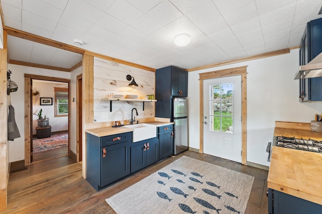 13491 80th St NW, Annandale, MN 55302 - kitchen with blue cabinetry, butcher block counters, open shelves, freestanding refrigerator, and crown molding