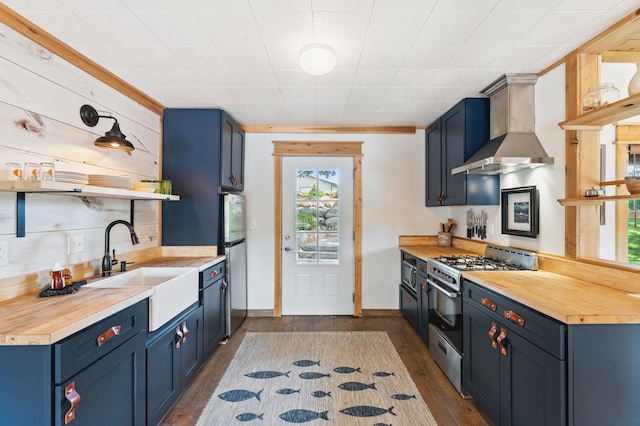 13491 80th St NW, Annandale, MN 55302 - kitchen with wall chimney range hood, stainless steel appliances, open shelves, blue cabinets, and butcher block countertops