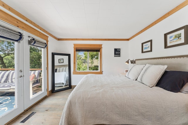 13491 80th St NW, Annandale, MN 55302 - bedroom with light wood-type flooring, access to outside, french doors, and crown molding