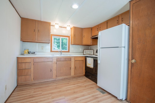 N6050 270th St, Lucas Twp, WI 54751 - kitchen with freestanding refrigerator, black electric range oven, under cabinet range hood, light countertops, and tasteful backsplash