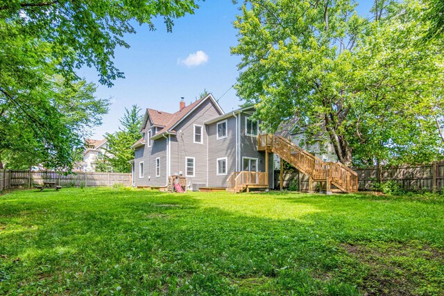 1066 Woodbridge St, Saint Paul, MN 55117 - rear view of property featuring a fenced backyard, stairway, a deck, and a chimney