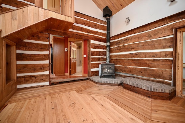 S3093 Baertsch Valley Rd, Cross Twp, WI 54629 - interior space with a wood stove, vaulted ceiling, and hardwood / wood-style flooring