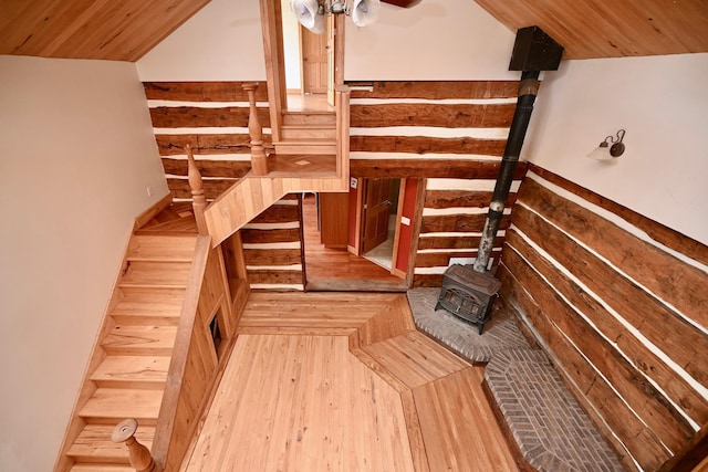 S3093 Baertsch Valley Rd, Cross Twp, WI 54629 - stairway featuring wood finished floors, vaulted ceiling, wooden ceiling, a wood stove, and wood walls