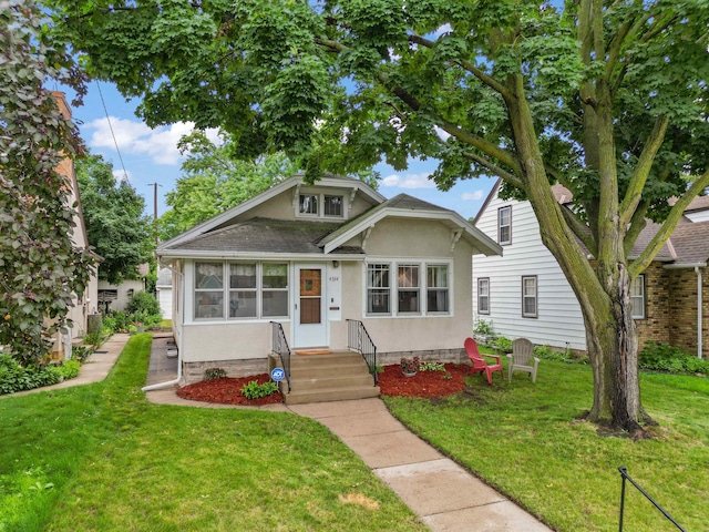 4334 Thomas Ave N, Minneapolis, MN 55412 - bungalow-style house with stucco siding, a front yard, and roof with shingles