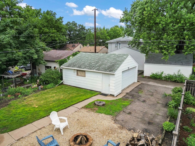 4334 Thomas Ave N, Minneapolis, MN 55412 - view of grassy yard with an outdoor fire pit, an outbuilding, and a detached garage