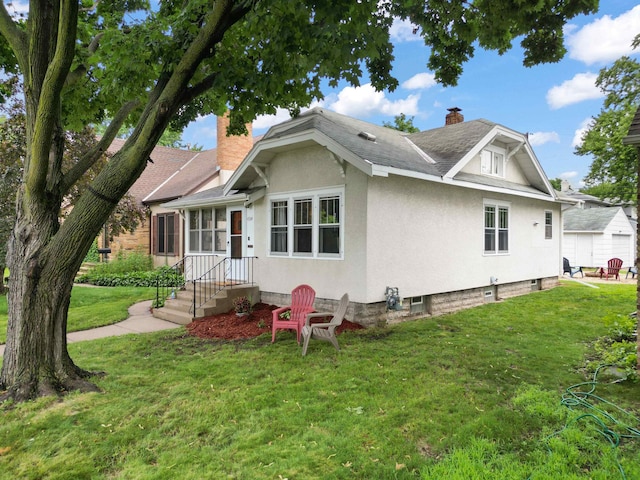 4334 Thomas Ave N, Minneapolis, MN 55412 - bungalow-style house with a chimney, a front lawn, stucco siding, and a shingled roof