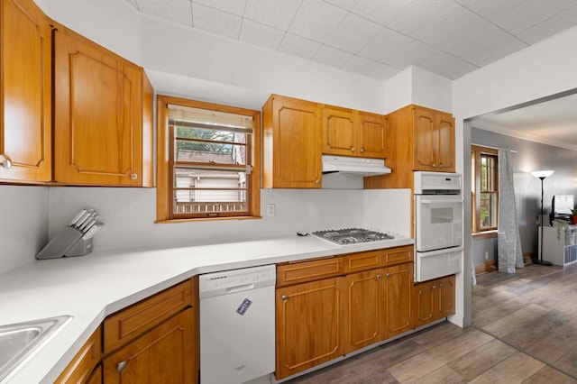 4334 Thomas Ave N, Minneapolis, MN 55412 - kitchen with white appliances, under cabinet range hood, a warming drawer, healthy amount of natural light, and ornamental molding