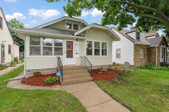 4334 Thomas Ave N, Minneapolis, MN 55412 - bungalow with a front yard, a shingled roof, and stucco siding