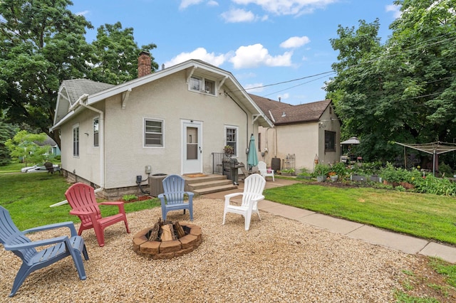 4334 Thomas Ave N, Minneapolis, MN 55412 - back of property featuring a chimney, an outdoor fire pit, a lawn, and stucco siding