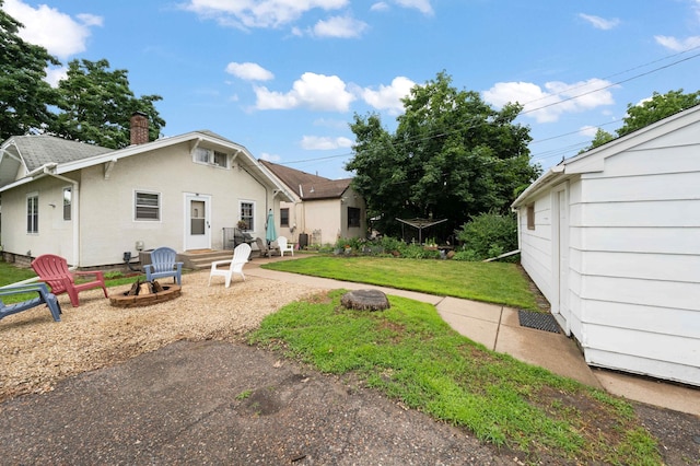 4334 Thomas Ave N, Minneapolis, MN 55412 - back of house featuring a chimney, a yard, a fire pit, and stucco siding