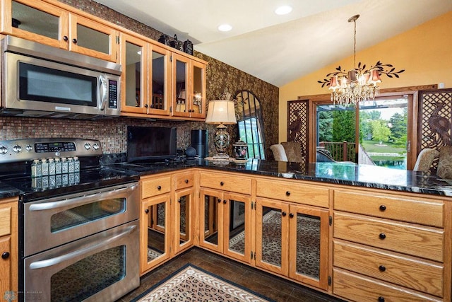 15 Fremont Dr S, Fargo, ND 58103 - kitchen featuring stainless steel appliances, vaulted ceiling, backsplash, a chandelier, and glass insert cabinets
