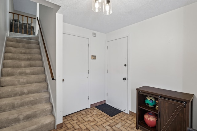 2365 Dorland Ln E, Maplewood, MN 55119 - foyer entrance featuring stairs, brick patterned flooring, and a textured ceiling