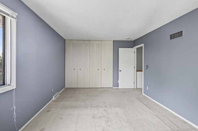 2365 Dorland Ln E, Maplewood, MN 55119 - unfurnished bedroom with carpet, a textured ceiling, and a closet