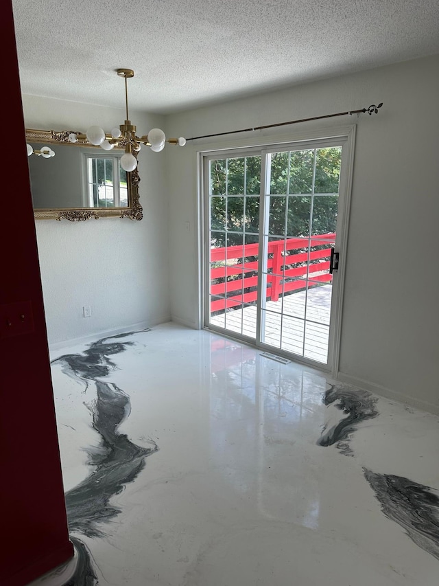 117 Quincy St, Alexandria, MN 56308 - unfurnished room with a chandelier, a textured ceiling, and concrete floors