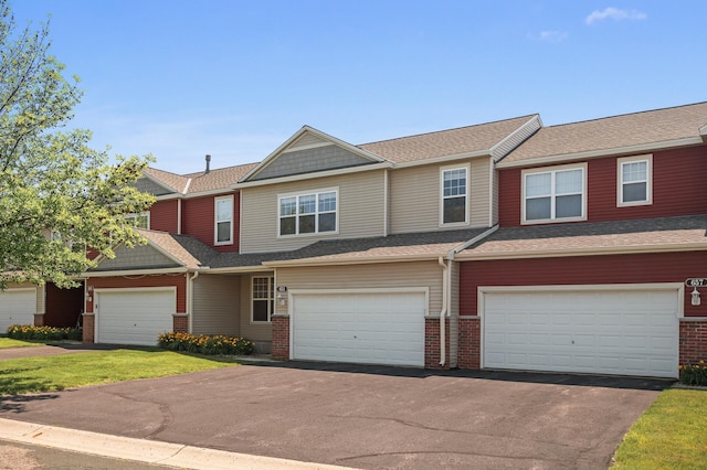 651 Ravencroft Rd, Waconia, MN 55387 - view of property featuring brick siding, asphalt driveway, an attached garage, and a front yard