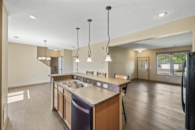 651 Ravencroft Rd, Waconia, MN 55387 - kitchen with stainless steel dishwasher, open floor plan, freestanding refrigerator, a breakfast bar area, and a textured ceiling