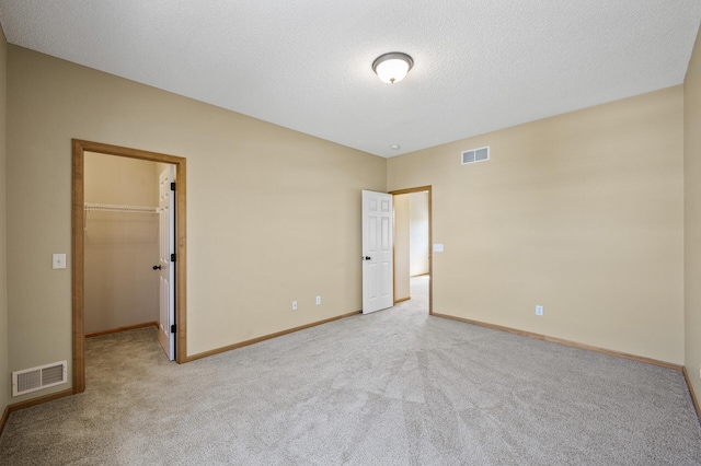 651 Ravencroft Rd, Waconia, MN 55387 - unfurnished bedroom with carpet flooring, a spacious closet, and a textured ceiling