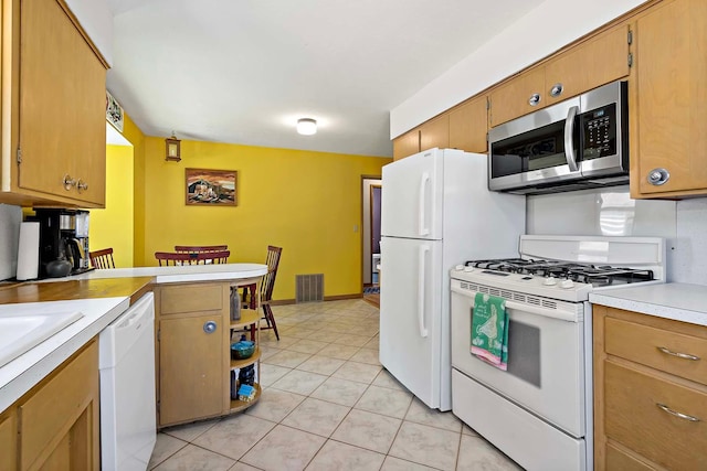 5501 30th Ave S, Minneapolis, MN 55417 - kitchen with white appliances, light countertops, light tile patterned flooring, a peninsula, and brown cabinets