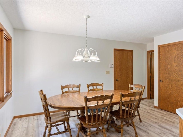 15170 141st Ave, Wadena, MN 56482 - dining room with light wood-style flooring, a chandelier, and a textured ceiling
