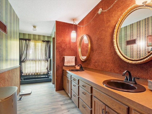 15170 141st Ave, Wadena, MN 56482 - full bath with wallpapered walls, double vanity, wood finished floors, and a textured ceiling