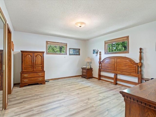 15170 141st Ave, Wadena, MN 56482 - bedroom featuring light wood-style floors, multiple windows, and a textured ceiling