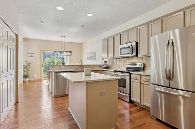 13915 52nd Ave N Unit 1204, Plymouth, MN 55446 - kitchen with appliances with stainless steel finishes, a textured ceiling, a peninsula, backsplash, and light wood-style flooring