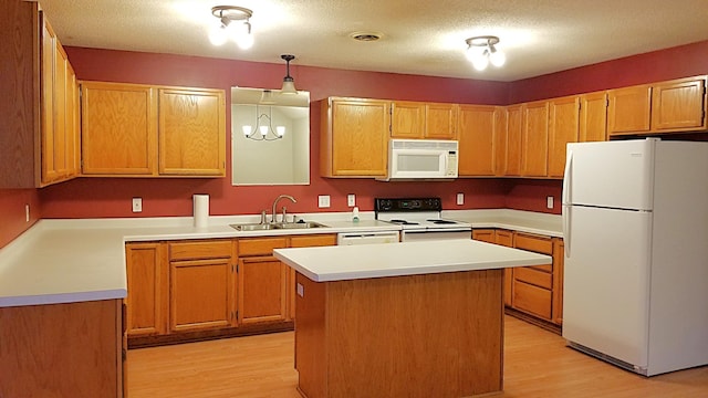 2236 Sacia Ln, Hudson, WI 54016 - kitchen with white appliances, light wood-style flooring, decorative light fixtures, light countertops, and a center island