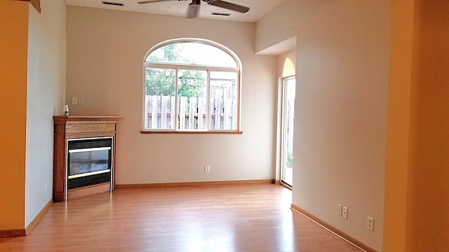 2236 Sacia Ln, Hudson, WI 54016 - unfurnished living room featuring ceiling fan, light wood-type flooring, and a glass covered fireplace