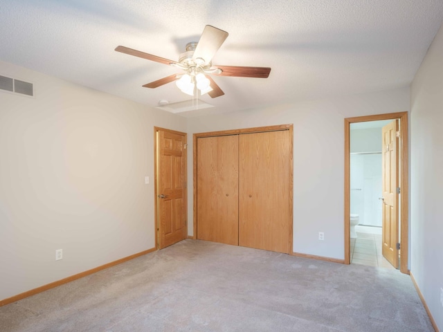 1618 Teton Ct NE, Rochester, MN 55906 - unfurnished bedroom featuring light carpet, a closet, ensuite bath, a ceiling fan, and a textured ceiling