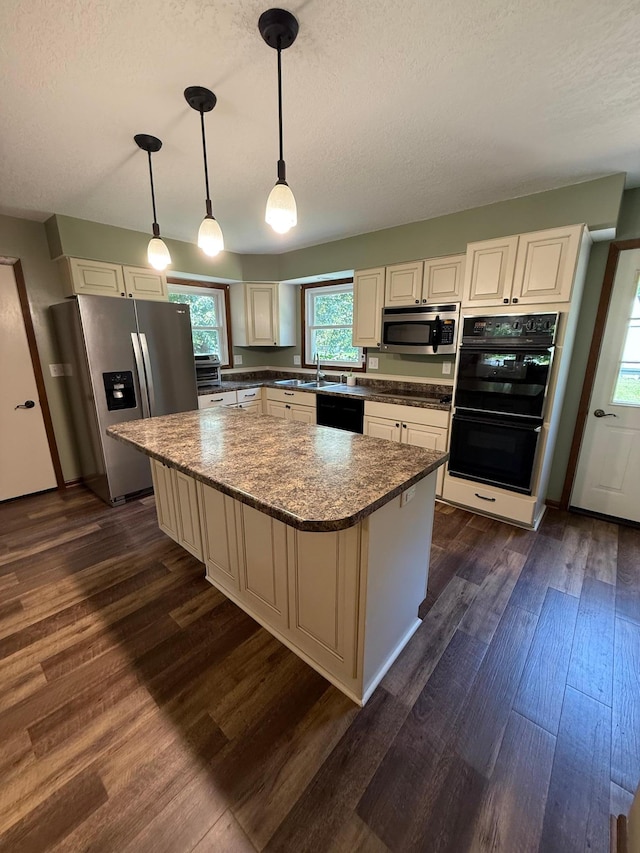 4527 Cushing Ave NW, Buffalo, MN 55313 - kitchen with black appliances, dark wood-style floors, a center island, a textured ceiling, and decorative light fixtures