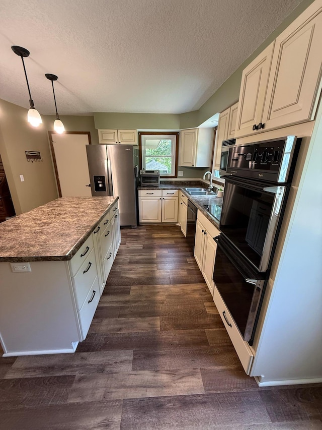4527 Cushing Ave NW, Buffalo, MN 55313 - kitchen featuring black appliances, a textured ceiling, dark wood-style flooring, a center island, and pendant lighting