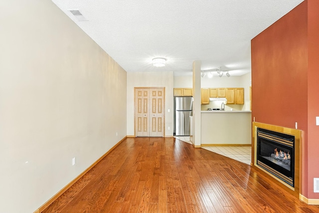 3730 Vermilion Ct S Unit 509, Eagan, MN 55122 - unfurnished living room with light wood-style floors and a glass covered fireplace