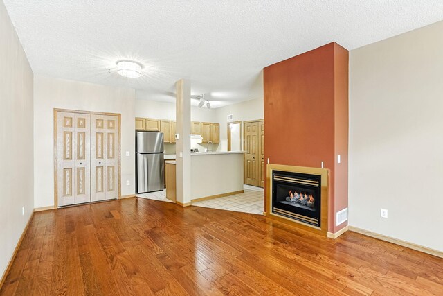 3730 Vermilion Ct S Unit 509, Eagan, MN 55122 - unfurnished living room with light wood-style flooring and a glass covered fireplace