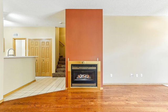 3730 Vermilion Ct S Unit 509, Eagan, MN 55122 - unfurnished living room featuring stairway, light wood-style flooring, and a lit fireplace