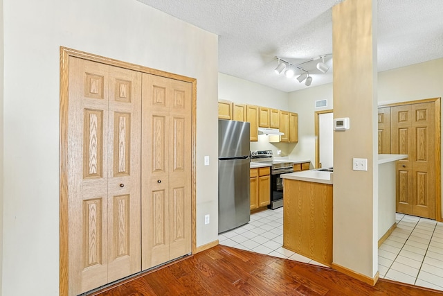 3730 Vermilion Ct S Unit 509, Eagan, MN 55122 - kitchen with stainless steel appliances, under cabinet range hood, light countertops, light tile patterned floors, and a textured ceiling