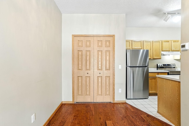 3730 Vermilion Ct S Unit 509, Eagan, MN 55122 - kitchen with stainless steel appliances, light countertops, under cabinet range hood, a textured ceiling, and light wood-style flooring