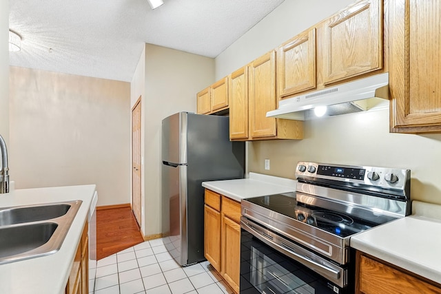 3730 Vermilion Ct S Unit 509, Eagan, MN 55122 - kitchen featuring appliances with stainless steel finishes, under cabinet range hood, light countertops, light tile patterned floors, and a textured ceiling