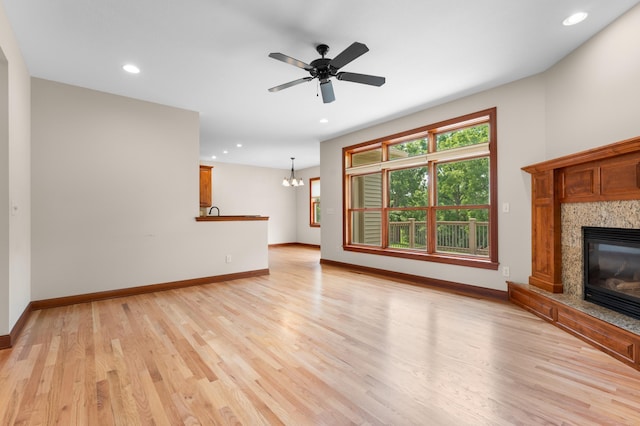 2309 Teakwood Ln SW, Rochester, MN 55902 - unfurnished living room featuring a fireplace, light wood-type flooring, recessed lighting, a chandelier, and ceiling fan