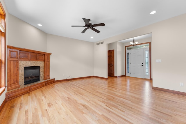 2309 Teakwood Ln SW, Rochester, MN 55902 - unfurnished living room featuring light wood-style flooring, a tile fireplace, a chandelier, ceiling fan, and recessed lighting