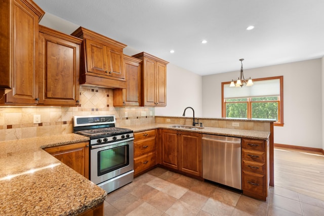 2309 Teakwood Ln SW, Rochester, MN 55902 - kitchen featuring appliances with stainless steel finishes, a peninsula, brown cabinetry, recessed lighting, and light stone countertops