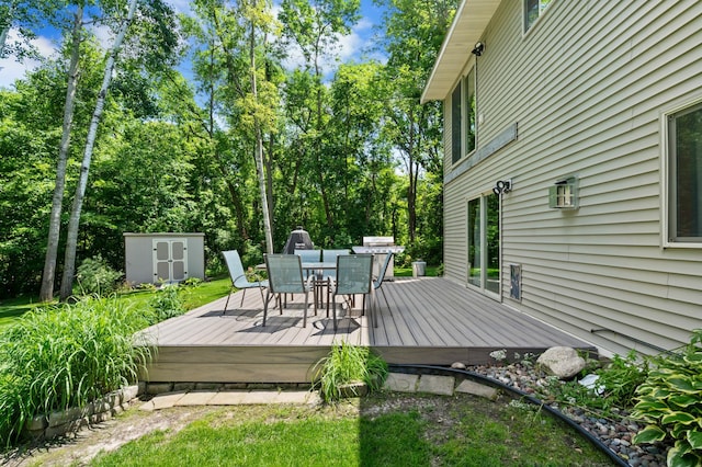 15784 103rd St SE, Becker Twp, MN 55308 - wooden deck with outdoor dining space, a shed, and view of scattered trees