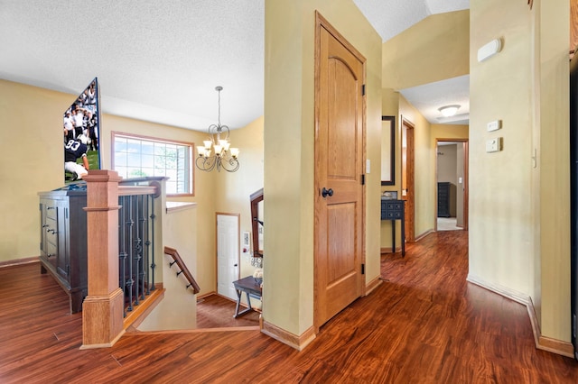 15784 103rd St SE, Becker Twp, MN 55308 - corridor with dark wood finished floors, an upstairs landing, lofted ceiling, a chandelier, and a textured ceiling