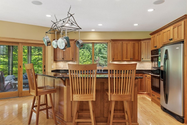 9449 Ehler Ave SE, Delano, MN 55328 - kitchen with stainless steel refrigerator with ice dispenser, black oven, healthy amount of natural light, light wood-style flooring, and recessed lighting